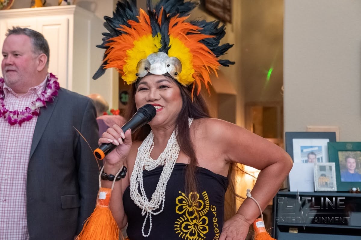 A hula dancer performing with a microphone at a birthday party