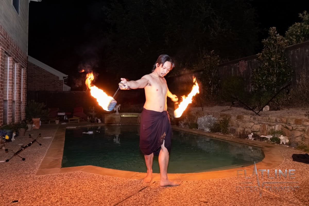 A fire performer twirling flames at a birthday party