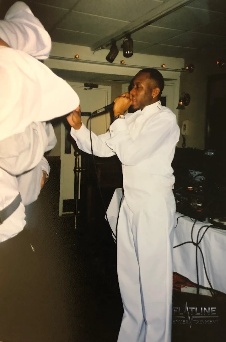 Mark Anthony performing live in a white suit, microphone in hand