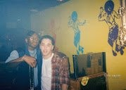 Mark Anthony and a guest smiling together at the DJ booth during the party